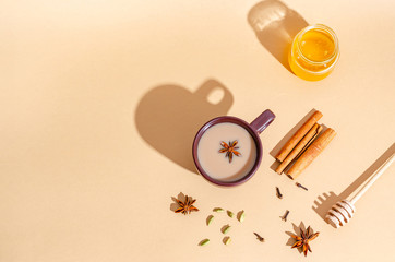 Traditional indian tea. Masala tea in a dark clay cup with ingredients, hard shadows