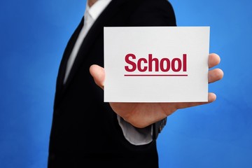 School. Lawyer in a suit holds card at the camera. The term School is in the sign. Concept for law, justice, judgement