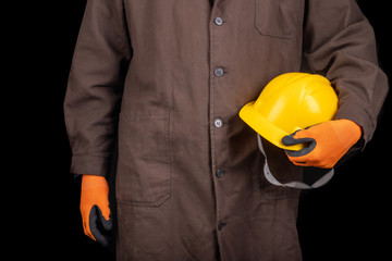 Fototapeta premium Production worker with work helmet in hand. A man dressed in work clothes.