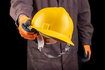 Production worker with work helmet in hand. A man dressed in work clothes.