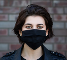 beautiful woman wear face mask on brick wall background.