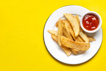French fries with ketchup sauce on yellow background