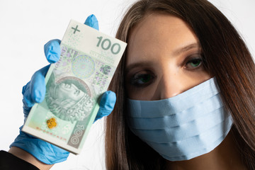 Businesswoman in a protective mask and protective gloves is holding a bundle of paper banknotes.