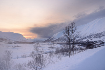Fototapeta premium Atardecer en las montañas nevadas del norte de Noruega, en Nordland, Tromso