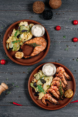fried salmon and shrimps on grey served table. traditional dish menu served in a restaurant. top view