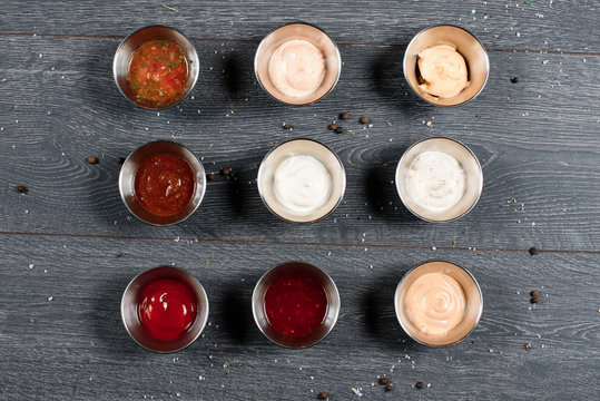 9 sause set on grey table. top view