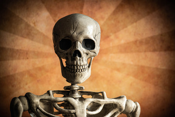 A plastic skeleton with a rugged grunge background of stripes or rays.