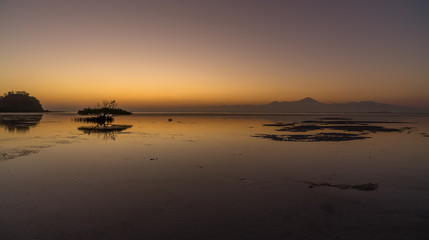 Magical vibrant gradual sunset scene with volcano or sunrise water like a glass in Sumbawa island, Indonesia