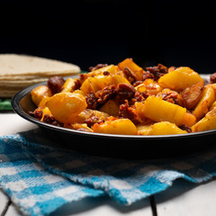 Mexican potatoes with chorizo on white background