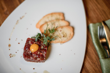 beaf tartar with garlic toast on white dish