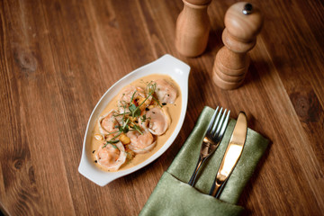 Shrimp raviolli served on wooden table