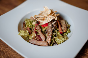grilled meat with fresh salad on grey served table. traditional dish menu served in a restaurant