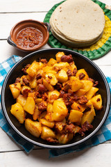 Mexican potatoes with chorizo on white background
