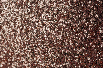 Brown-gold sparkles close-up. Bright festive background for sites and layouts