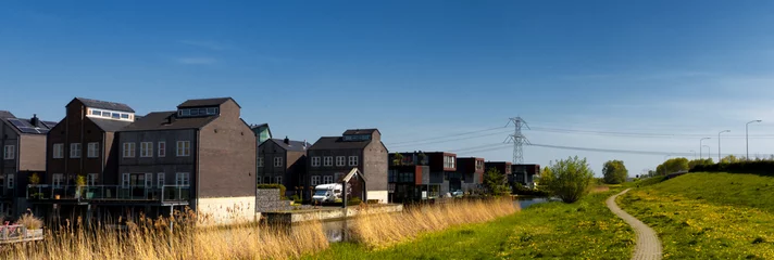 Foto auf Leinwand Residential buildings next to a canal, in a green environment, in Almere Buiten, Netherlands © Catalin