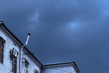 Fototapeta na wymiar house with a pipe in a stormy sky