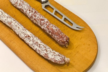 salami and knife on a wooden cutting board