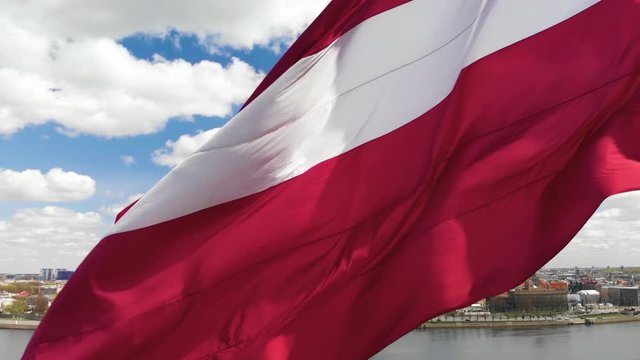 Close view of latvian flag fluttering on wind with Riga old town background