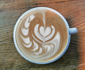 Delicious cup of coffe with latte art pattern, top view, flat la