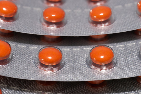 Orange pills in a blister pack. background image