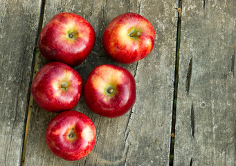 red apples on an old, worn garden table