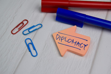 Diplomacy write on sticky notes isolated on office desk