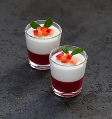 Creamy berry dessert Panna cotta vanilla with strawberries in a glass on a dark gray background