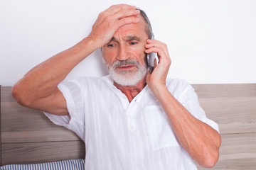 Sick elderly man calling a doctor 