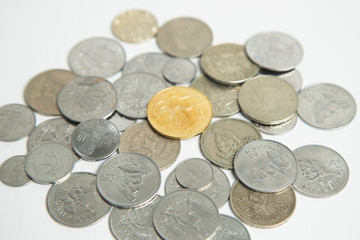 Pile of gray coins with a golden coin in the center - coins on white background - currency of Guatemala