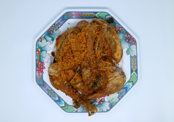 Fried chicken with crispy spiced flakes on white background. Indonesian fried chicken or ayam goreng kremes.