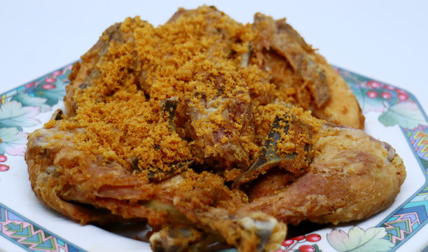 Fried chicken with crispy spiced flakes on white background. Indonesian fried chicken or ayam goreng kremes.