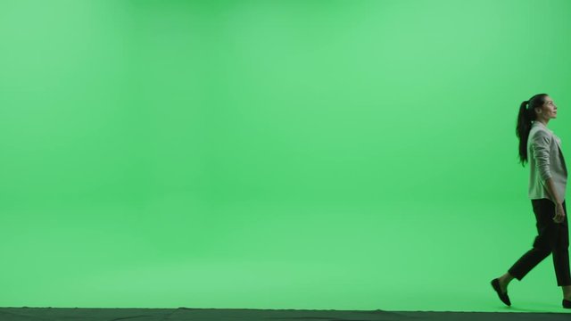 Green Screen Chroma Key Studio: Beautiful Mature Woman Wearing Stylish Business Casual Clothes Walks Across Room. Side View Camera Shot