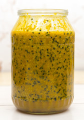 Therapeutic mixture with honey from sesame seeds, turmeric, caraway seeds and ginger on a glass jar on the table