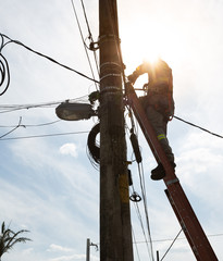 Electrician worker working on a high voltage pole
