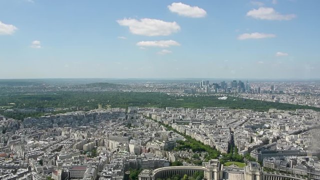 Slow cinematic pan to la Defense business district major business district in Paris with iconic cityscape skyline and clear blue sky - multiple headquarters and business offices for big companies 