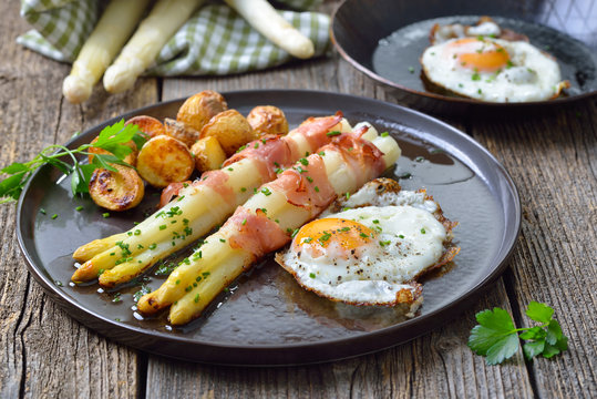Gebackener Spargel mit Speckstreifen, Ofenkartoffeln und Spiegelei –Baked white asparagus with bacon strips, crunchy potatoes and fried eggs