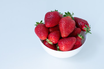 strawberries in a white ceramic glass on white background
