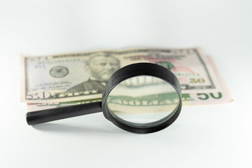 money dollars and euros through a magnifier. On white background