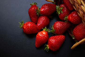 an overturned braided basket with scattered trawberries
