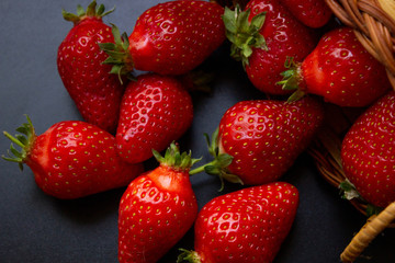 an overturned braided basket with scattered trawberries