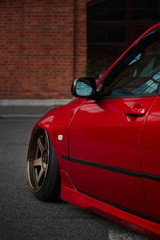 Red low stance car with beautiful wheels with low profile rubber