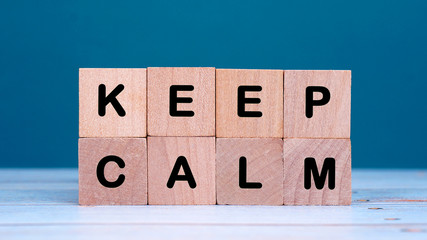 keep calm taxt on wooden block at green background