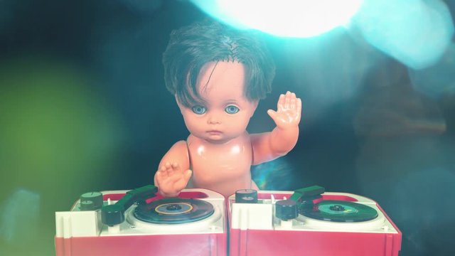 Plastic doll djing on toy record player.