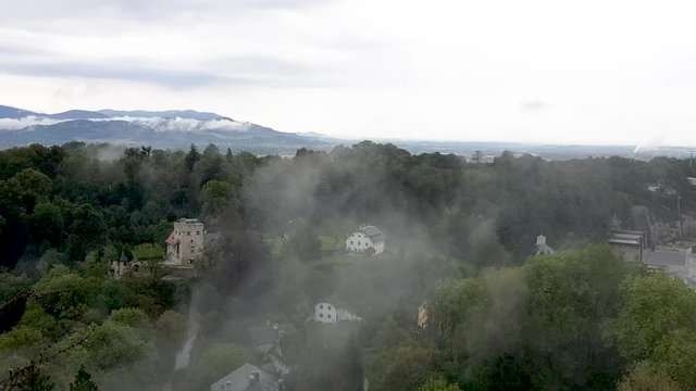 Freyschlosschen, Red Tower on the Monchsberg in the city of Salzburg. View from Hohensalzburg Fortress on a cloudy and foggy sommer day.