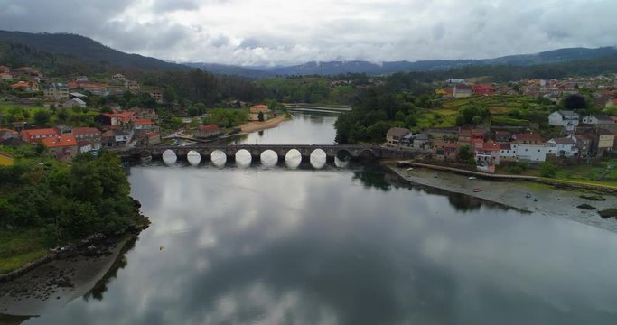 Aerial view of a stone bridge with cars driving across a river in Pontevedra, Spain