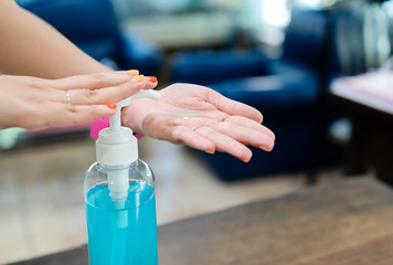 women washing hands with alcohol gel