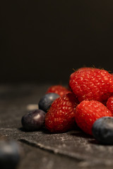 Close-up of berries (blueberries, raspberries) on a dark background.