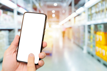 Touch screen smartphone in a hand. Warehouse industry blur background