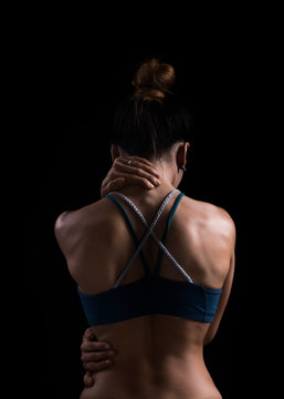Neck pain during training. Athlete running asian woman runner with sport injury in sports bra rubbing and touching upper back muscles 