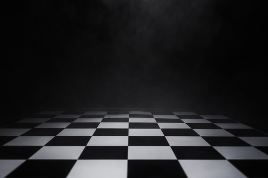 empty chess board with smoke float up on dark background © Thitiwat.Day